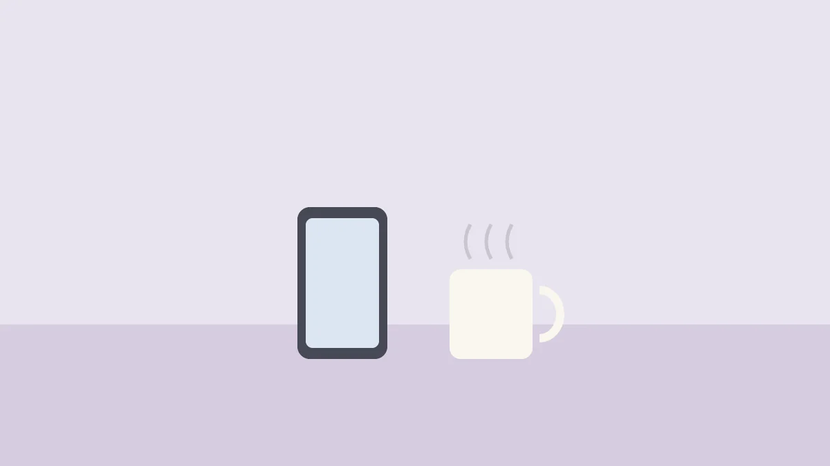 テーブルの上のスマホと湯気の立つマグカップ